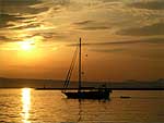 barca a vela all'alba isola di San Pietro (CA)